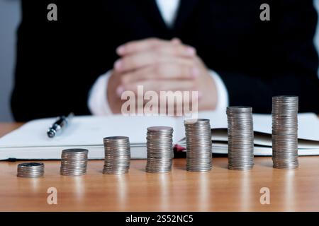 Ragioniere verificare il business e risparmio di denaro di impilamento delle monete in oro con la calcolatrice. Concetto di contabilità. Foto Stock