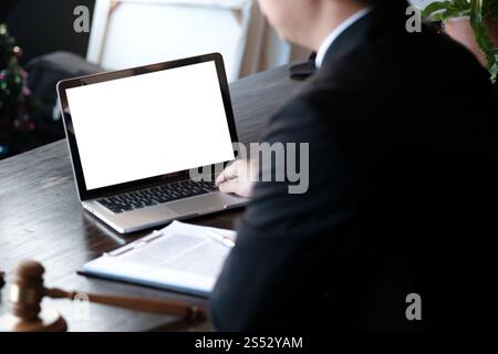 Uomo che lavora utilizzando un computer portatile su un tavolo di legno. Digitazione con le mani su una tastiera Foto Stock