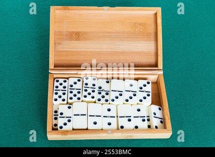 Set di bianco tessere del domino in scatola di bambù verde baize tabella Foto Stock