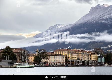 Lugano, Svizzera - 22 dicembre 2024: Il centro della città sul lago di Lugano, abbracciato da montagne nebbiose e velate di nuvole Foto Stock