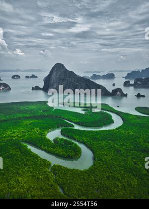 Vista aerea della baia di Phang Nga, Thailandia. Le lussureggianti mangrovie verdi e i tortuosi corsi d'acqua incorniciano le spettacolari formazioni carsiche calcaree in questa splendida scena tropicale Foto Stock
