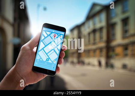 Primo piano del turista utilizzando la navigazione con mappa GPS sulla schermata dell'applicazione dello smartphone per la direzione verso l'indirizzo di destinazione in città con viaggio e. Foto Stock