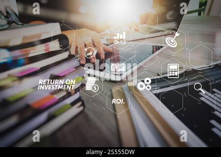 Indicatore ROI ROI Return on Investment nel dashboard virtuale per migliorare il business. designer che lavora a mano con tablet digitali e computer portatili e. Foto Stock