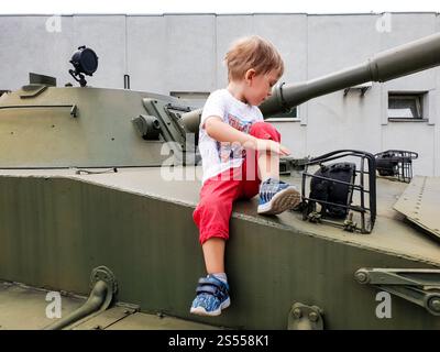 Foto di un bambino seduto sulla torre del carro armato al museo della guerra mondiale Foto Stock