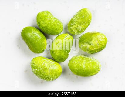 Diversi edamame surgelati (soia non matura) primo piano sulla piastra in ceramica grigia Foto Stock