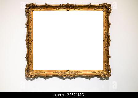 vecchia cornice ornamentale dorata con tela tagliata su grigio parete Foto Stock