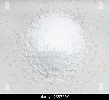 vista dall'alto del cumulo di sostituto dello zucchero - estratto cristallino di pianta di stevia primo piano su piastra di ceramica grigia Foto Stock