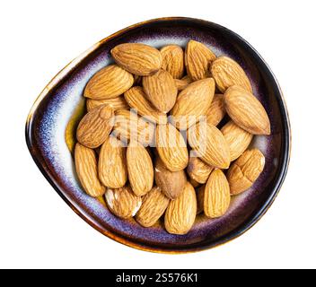 vista dall'alto di semi di mandorle grezze in ciotola di ceramica isolata su sfondo bianco Foto Stock