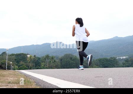Donna attiva e sana che lega scarpe da corsa, jogging runner salute e benessere concetto Foto Stock