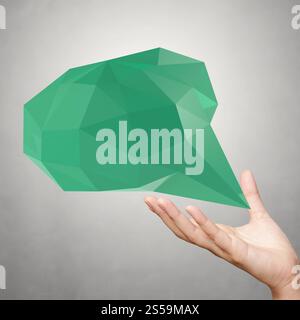Mano che mostrano una bassa poli geometrica bolla del parlato su sfondo bianco Foto Stock