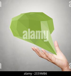 Mano che mostrano una bassa poli geometrica bolla del parlato su sfondo bianco Foto Stock