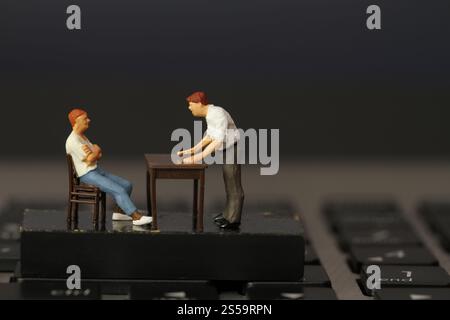 lavorare online in miniatura capo uomo d'affari arrabbiato con il dipendente su un computer portatile Foto Stock