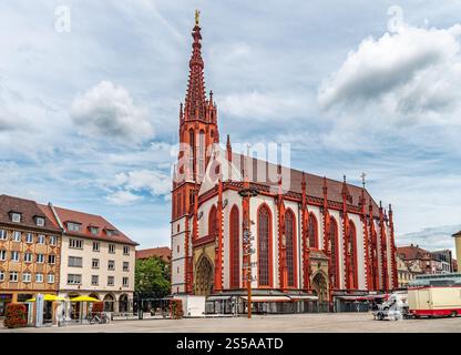 Una splendida chiesa storica in stile gotico con intricati dettagli rossi situata in una pittoresca piazza della città europea sotto un cielo parzialmente nuvoloso, creando Foto Stock