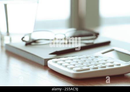 Close up di documenti aziendali su office la tabella con la calcolatrice e occhiali Foto Stock