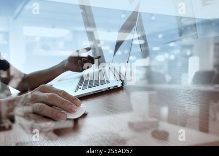 Doppia esposizione di business man mano lavorando sul computer laptop sulla scrivania di legno come concetto Foto Stock
