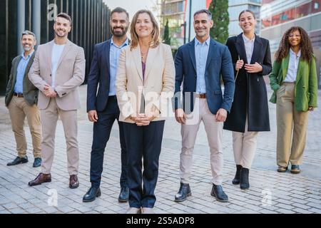 Professionisti che lavorano insieme e guardano la fotocamera all'aperto Foto Stock