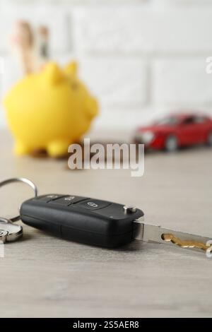 Chiave per auto con portachiavi su tavolo in legno chiaro, primo piano. Comprare auto Foto Stock