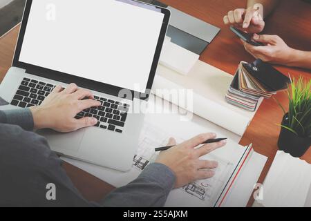vista dall'alto di due colleghi interior designer che discutono i dati con un nuovo computer laptop moderno con schermo vuoto e un tablet digitale professionale con esempio Foto Stock