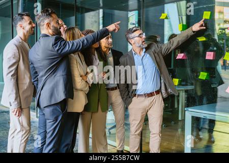 Team di professionisti che si occupa di brainstorming con Sticky Notes in Modern Office Foto Stock