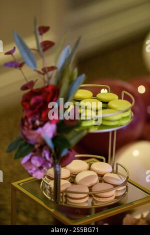 Primo piano di pistacchio e macaron di caffè (macaron francese) su un banco per torte a due piani Foto Stock