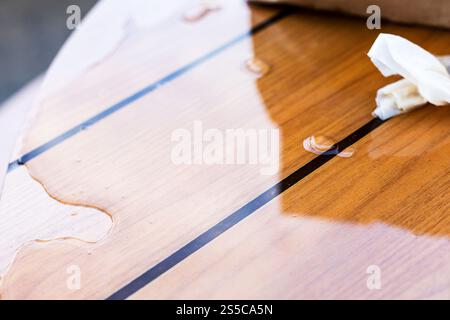 puddle di birra versata sulla superficie di un tavolo in legno nella caffetteria all'aperto la sera d'estate Foto Stock