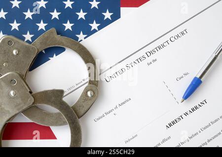 Documenti del tribunale distrettuale con manette e penna blu sulla bandiera degli Stati Uniti. Concetto di permesso per arrestare un sospetto. Distretto Foto Stock