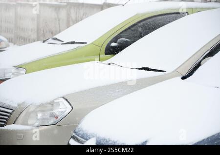 Frammenti di auto parcheggiate ricoperte di neve bianca. Frammenti di auto parcheggiate ricoperte di neve Foto Stock