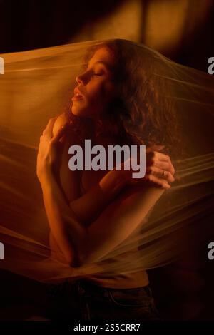 Ripresa verticale di una donna piuttosto tenera che si abbraccia mentre si nasconde il velo coperto Foto Stock