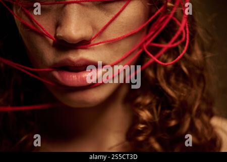 Primo piano della parte inferiore del viso femminile con un bel naso e labbra morbide con fili rossi Foto Stock