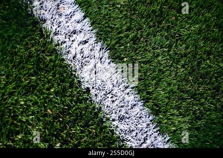 Striscia bianca su un luminoso verde erba artificiale al campo di calcio Foto Stock