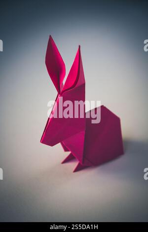 Origami di coniglio di carta rosa isolato su uno sfondo vuoto. Origami di coniglio in carta rosa isolato su sfondo vuoto Foto Stock