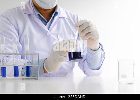 Scienza innovativo maschio medico o ricercatore di laboratorio scientifico esegue test con liquido in laboratorio. esperimenti scientifici sulle apparecchiature Foto Stock