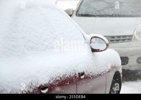 Frammenti di automobili parcheggiate ricoperte di neve Foto Stock