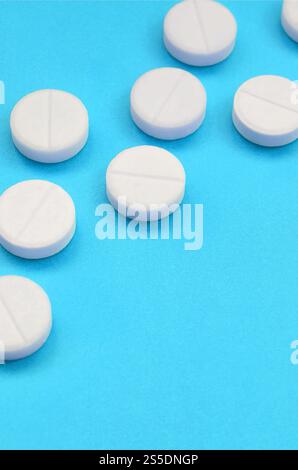 Un paio di compresse bianche giacciono su un blu brillante superficie di sfondo. Immagine di sfondo sul farmaceutico e medico, argomenti Foto Stock