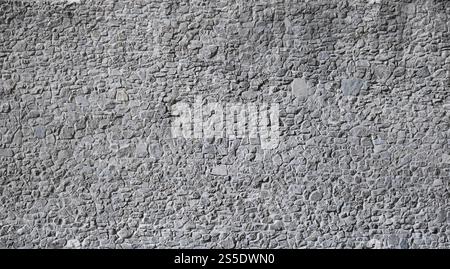 Parte di un antico castello struttura di un muro di pietra come sfondo. Schema di parete decorativa in pietra di dimensioni casuali con collegamento in calcestruzzo. Fa parte di un vecchio Foto Stock