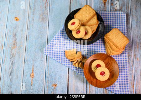 Impilare molti tipi di biscotti su un piatto e metterli su un tavolo di legno. Foto Stock
