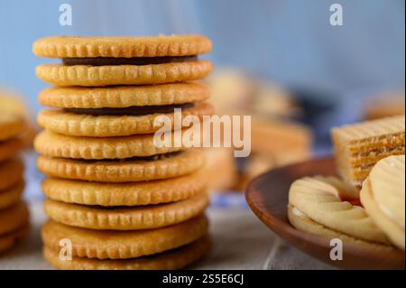 Impilare molti tipi di biscotti su un piatto e metterli su un tavolo di legno. Foto Stock