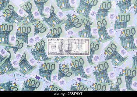 100 dollari di banconota si trova su una serie di tagli monetari verdi di 100 euro. Molti soldi formano un mucchio infinito Foto Stock