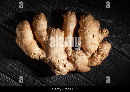 zenzero su sfondo in legno nero Foto Stock