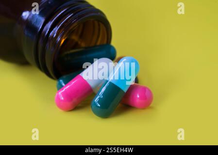 Pillole mediche che fuoriescono da un flacone di pillole rovesciato Foto Stock