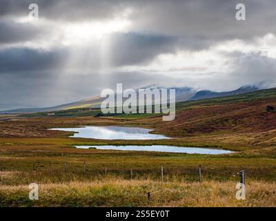 Splendida vista sulle montagne durante il viaggio in auto in Islanda. Spettacolare paesaggio islandese con natura panoramica: Montagne, campi, nuvole, laghi, ghiacciai. Foto Stock