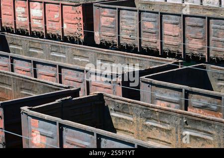 I vecchi vagoni ferroviari vuoti e arrugginiti sui binari in estate. Carri sporchi alla luce del sole all'aria aperta. I vecchi vagoni ferroviari vuoti e arrugginiti sui binari in estate Foto Stock