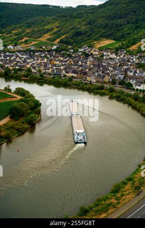 Vista aerea di una nave da carico che naviga attraverso l'ansa del fiume Mosella accanto a un pittoresco villaggio con vigneti sulla collina, la valle della Mosella, Germania Foto Stock