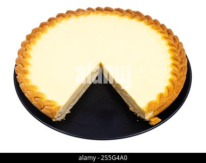 tagliare la cheesecake (torta acida alla crema) su un piatto nero isolato su fondo bianco Foto Stock