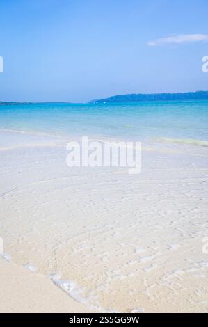 Spiaggia isolata e incontaminata di sabbia bianca con onde ondulate e immagini del cielo azzurro viene scattata alla spiaggia di Radhanagar a Havelock Island nelle Andamane e NIC Foto Stock