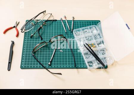 kit per la riparazione di occhiali usati su tavolo in legno Foto Stock