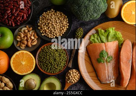 Legumi, frutta e salmone su un piatto di legno. Foto Stock