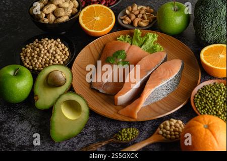 Legumi, frutta e salmone su un piatto di legno. Foto Stock