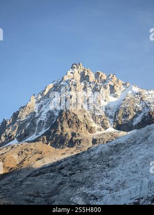 Cima innevata dell'aiguille du Midi Monte bianco che sorge sopra la valle di chamonix in vivaci colori autunnali sotto il cielo azzurro Foto Stock