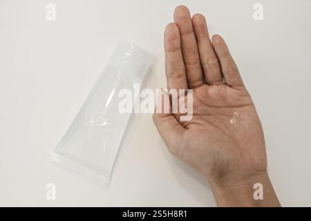 Donne che indossano camicie bianche che premono il gel per lavarsi le mani e pulire le mani. Foto Stock